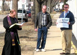 Image of The priests in Rockford quietly stand vigil in every type of inclement weather with open coats, so that the women seeking an abortion are aware that a priest is present in his flowing, seemingly flaming cassock. 
