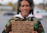 Image of Ted Williams displays the sign he used to beg for money along a highway in Columbus, Ohio.