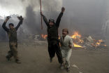 Image of Pakistani men rejoice after burning Christian homes during an anti-Christian riot earlier this year.