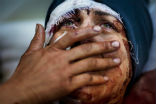 Image of A Syrian woman mourns as her town is razed by Islamist rebels. 