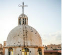 Image of A church tower riddled with bullet holes. Christians are finding it harder to remain neutral as jihadists close in. 