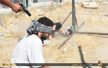 Image of A victim of ISIS kneels for a photograph and waits for the bullet that will end his life. 