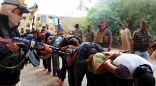 Image of Fighters from the Islamic State watch over captured Syrian soldiers.