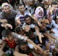 Image of Iraqi refugees hungrily receive a shipment of food aid, which has become even more scarce now the UN has halted shipments. 