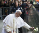Image of Pope Francis lays a flower on the 9/11 memorial before leading a prayer service. 