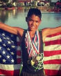Image of Michael Riley Jr., three-time Junior Olympic qualifier posing with his medals.