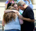 Image of Survivors embrace and pray in the aftermath of the shooting which left 9 people and the shooter dead. 