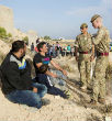 Image of British soldiers question refugees, trying to ensure that none of them are ISIS operatives. Regardless, ISIS now knows of the security flaw. 