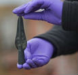 Image of An archaeologist holds a spear point recovered from the site. The artifacts are so well preserved, they're providing a detailed look into Bronze Age life. 