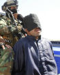 Image of An Iraqi militia takes an ISIS captive into custody. Not all of the captives will have the luxury of a fair trial. 