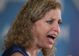 Image of Debbie Wasserman Schultz attempts to stand against her critics (YouTube).