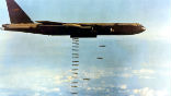 Image of A B-52 bomber drops bombs during the Vietnam War.