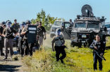 Image of Heavily armed police prepare to move in against protestors in North Dakota. 