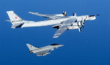 Image of A NATO fighter escorts a Russian long-range bomber. Several such flights have occurred recently as the Russians assert themselves as a superpower once more. 