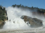 Image of Water rushes down the spillway and into the eroded area outside the dam. Erosion is threatening the integrity of the system and up to a quarter million people could be affected.