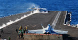 Image of F-18 jets fly from the deck of the USS Carl Vinson. 