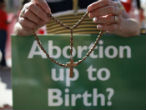 Image of A protestor prays as the BMA debates Measure 50.