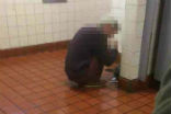 Image of An addict huddles on the floor of a public restroom. Opioids cause the user to stop caring about things most people care about. 