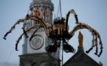 Image of The giant spider woke up on cue, and walked into the streets below, amazing the crowd. But not everybody appreciated the display. 