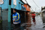 Image of People walk though flooded streets in the aftermath of Maria. Several places remain flooded.