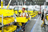 Image of Amazon workers are being replaced by robots, but they aren't being laid off either. The growth of online retail means they can fill other roles, as the workload increases. 