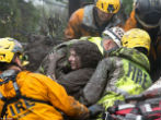 Image of A woman is rescued by firefighters. At least 15 are dead, and search and rescue efforts are ongoing. 