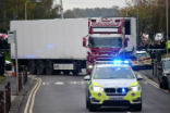 Image of Police officers drive away a lorry in which was discovered 39 dead bodies at Waterglade Industrial Park in Grays east of London Oct 23 2019